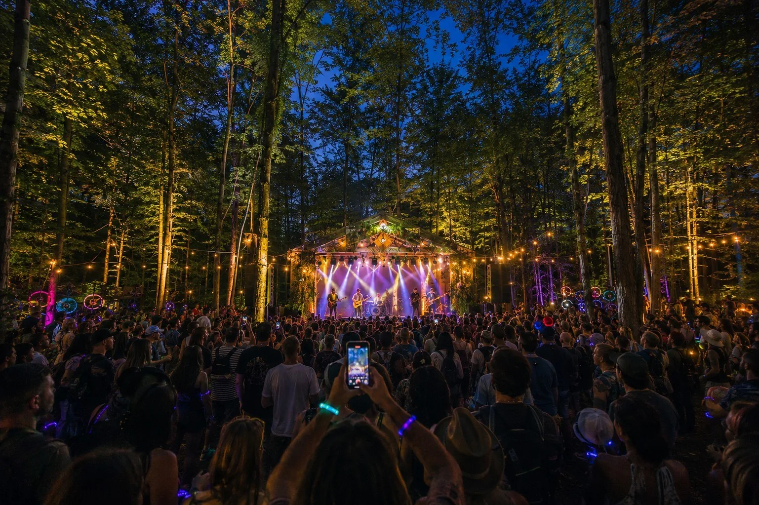 Nova stage in the forest at dusk with a live band under warm lights